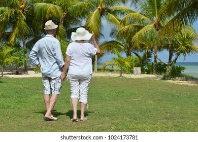 elderly couple running  on beach - Powered by Shutterstock