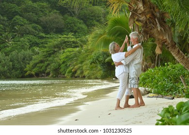 elderly couple running  on beach - Powered by Shutterstock