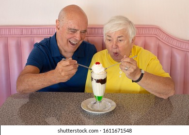 Elderly Couple Sharing Ice Cream At Soda Shop
