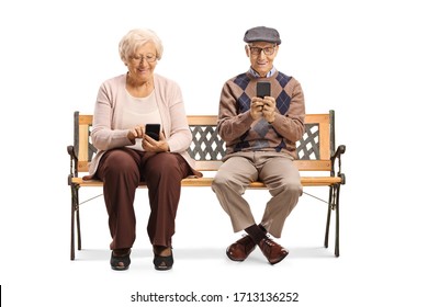 Elderly Couple Sitting On A Bench And Using Mobile Phones Isolated On White Background