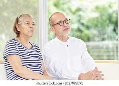 Elderly Couple Sitting On The Couch And Having A Serious Conversation