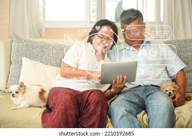 Elderly Couple Sitting On Sofa Using Tablet Watching Hologram Online Health Check, With Two Dogs Sitting On Sofa In Living Room, Health And Technology Concept.