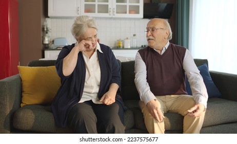 An elderly couple sitting in their armchair at home. Image of an elderly couple in troubled marriages. Old man comforting his crying, sad wife. - Shutterstock ID 2237575677