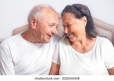 Elderly Couple Sitting Together On Devan And Looking At Each Other