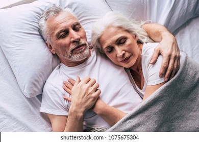 The elderly couple sleeping on the bed