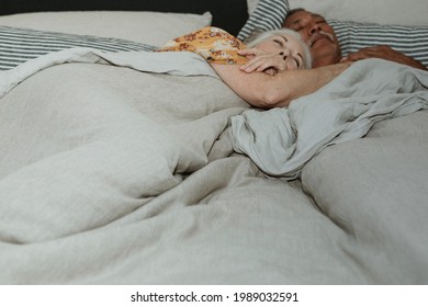 Elderly Couple Sleeping On A Bed