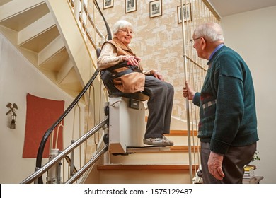 Ältere Paare auf der Treppe mit Treppenlift