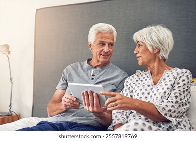 Elderly couple, tablet and happy in bedroom for morning, wake up and relax in home as pensioner. Senior people, smile and bonding on technology for relationship, marriage and partners in retirement - Powered by Shutterstock