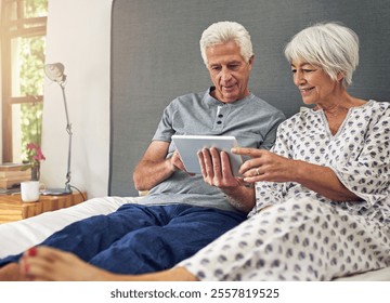 Elderly couple, tablet and smile in bedroom for watching, online or relax in home as pensioner. Senior people, happy and bonding on technology for connection, communication or partners in retirement - Powered by Shutterstock