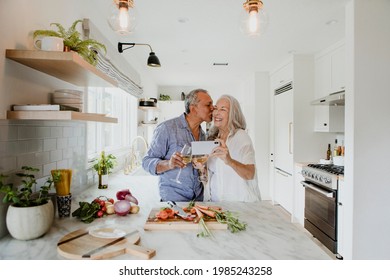 Elderly Couple Taking A Selfie While Cooking In A Kitchen