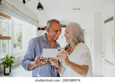 Elderly couple taking a selfie while having a wine - Powered by Shutterstock