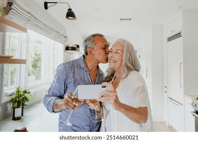 Elderly couple taking a selfie while having a wine - Powered by Shutterstock