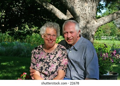 An elderly couple, in their backyard.