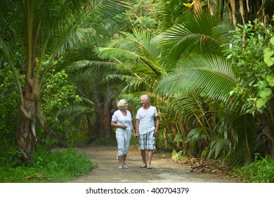 Elderly couple  in tropical garden - Powered by Shutterstock