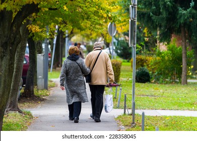 Elderly Couple Walking In The City.