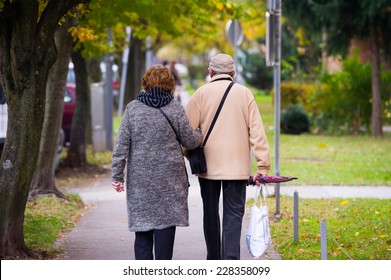 Elderly Couple Walking In The City.
