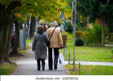 Elderly Couple Walking In The City.