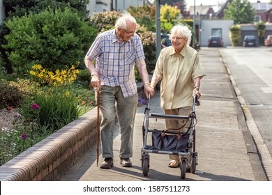 Elderly Couple with Walking Frame and Stick on the Sidewalk - Powered by Shutterstock