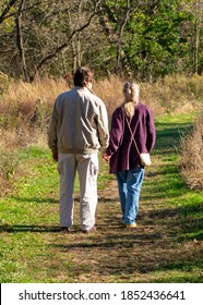 An Elderly Couple Walking On A Path In A Crop Field On A Bright Autumn Day In Valley Forge National Historical Park