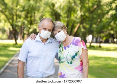 Elderly Couple Wearing Medical Face Mask In The Summer Garden. Health Concept. Corona Virus. 