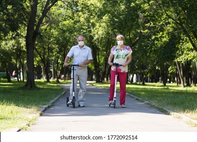 elderly couple wearing medical face mask  riding a scooters in the park. Active Seniors. health concept. Corona Virus.  - Powered by Shutterstock