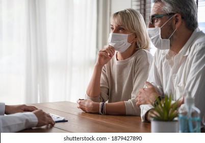 Elderly couple wearing protected face mask while listening or discussing  with a man at the table with looking stress atmosphere. Shot of senior people consultation for medical health insurance. - Powered by Shutterstock