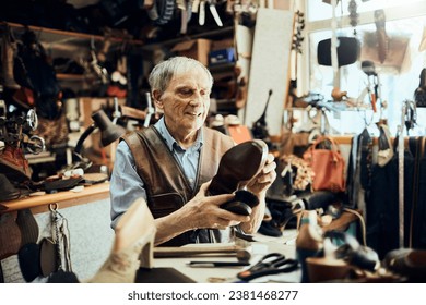 Elderly craftsman inspecting a handcrafted shoe in his traditional workshop - Powered by Shutterstock