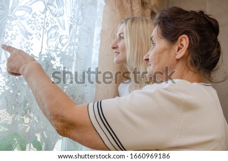 Similar – Caregiver looking through the window with elderly patient in wheelchair