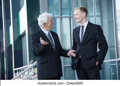 Elderly Director And Young Worker Talking Outside The Building