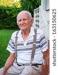 Elderly eighty plus year old man outdoors in a home setting.