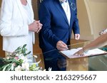 Elderly elegant couple signing marriage agreement at desk. Man