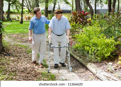 Elderly father and adult son out for a walk in the park.