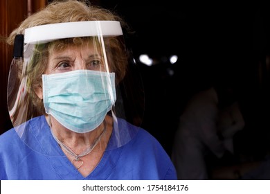 Elderly Female Doctor With Face Mask And Protective Shield, Isolated On Black Background