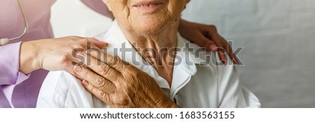 Elderly female hand holding hand of young caregiver at nursing home.Geriatric doctor or geriatrician concept. Doctor physician hand on happy elderly senior patient to comfort in hospital examination Stockfoto © 
