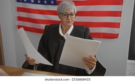 Elderly female judge examines documents in a courtroom with an american flag backdrop, signifying justice and professionalism in the united states legal system. - Powered by Shutterstock