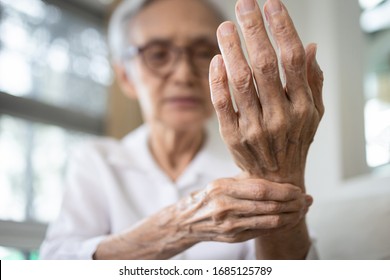Elderly female patient suffer from numbing pain in hand,numbness fingertip,arthritis inflammation,beriberi or peripheral neuropathies,senior woman massage her hand with wrist pain,rheumatoid arthritis