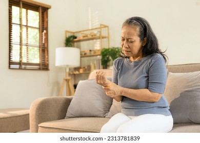 Elderly female patient suffers from inflammatory wrist pain, beriberi or peripheral neuropathy, elderly woman massaging hands with wrist pain