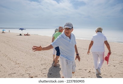 elderly friends all walk together at the beach by the sea
 - Shutterstock ID 2237850905