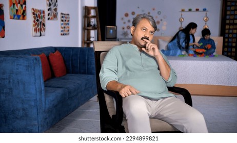 An elderly grandfather - the worried man, stressed life, lonely old man, thinking about problems. An old man sitting on a rocking chair - lost in thoughts, small family, joint family, Indian household