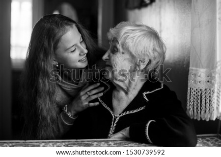 Young woman talking to elderly woman in wheelchair