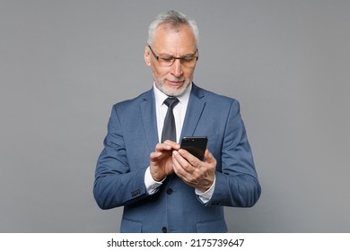 Elderly Gray-haired Mustache Bearded Business Man 50s In Classic Blue Suit Shirt Tie Use Mobile Phone Typing Sms Message Isolated On Grey Background Studio. Achievement Career Wealth Business Concept