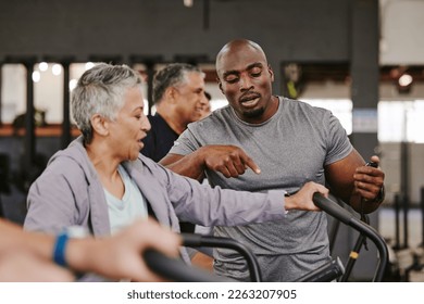 Elderly group, exercise bike and personal trainer for fitness, timer and retirement wellness by blurred background. Senior woman, bicycle training and diversity with black man, progress and coaching - Powered by Shutterstock