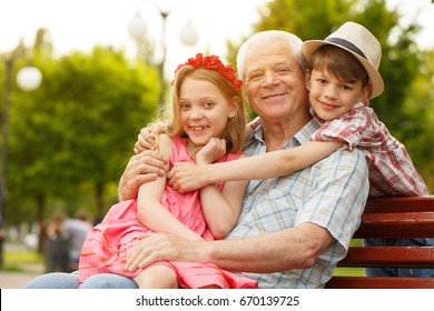 Elderly Happy Man Smiling Enjoying Resting At The Park With His Cute Little Grandkids Copyspace Family Boy Girl Siblings Family Bonding Leisure Holidays Happiness Nature Seasonal Retirement Concept