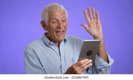 Elderly Having Video Chat Waving Using Digital Tablet Computer Screen. Retired Old Man Spend Time Talking To Friends And Family Isolated On Solid Purple Background