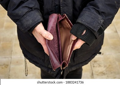 An Elderly Homeless Poor Woman Holds An Empty Wallet, Or Purse. The Concept Of Poverty In Retirement. Global Extreme Poverty. No Money Help Me. Covid-19 Global Financial Crisis.