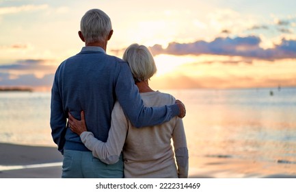 Elderly intelligent couple in love romantically spending time on the beach near the sea, gently hugging each other, looking at the sunset. - Powered by Shutterstock