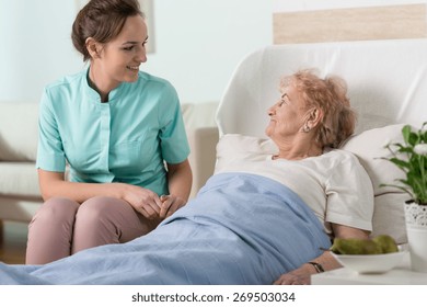 Elderly Lady In A Hospital Bed And A Young Nurse