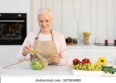 Elderly Lady Preparing Dinner Cooking Standing In Modern Kitchen. Older Woman Making Healthy Vegetable Salad Mixing Ingredients In Bowl At Home. Nutrition And Recipes Concept