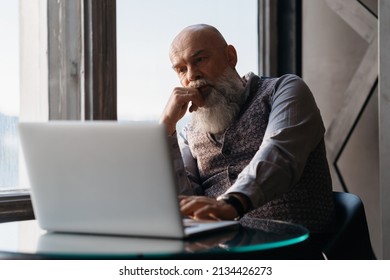 Elderly Liquor Store Owner Works On A Laptop .