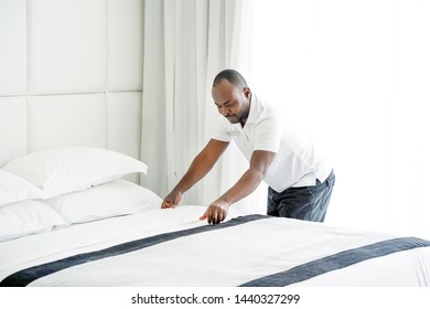 Elderly Maid Making Bed In Hotel Room. Staff Maid Making Bed. African Housekeeper Man Making Bed.